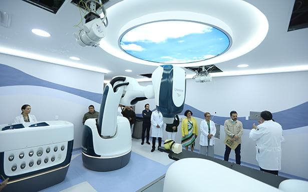 Sala de tratamiento del IMSS con tecnología avanzada para el tratamiento del melanoma ocular, médicos y personal observando el equipo.