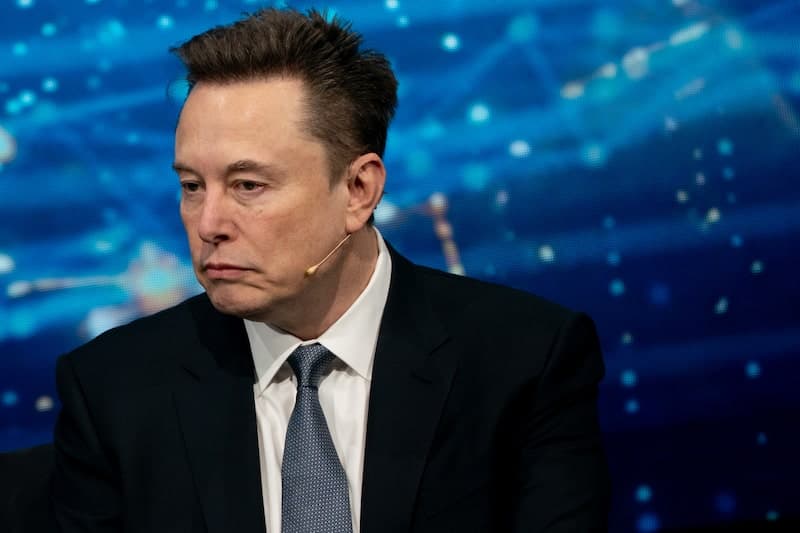 Elon Musk con expresión seria durante un evento, reflejando la reciente caída en el valor de SpaceX y su patrimonio neto.
