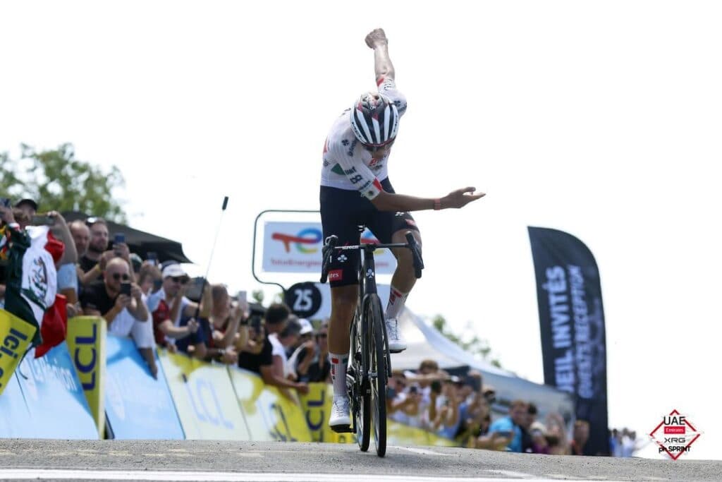Isaac del Toro celebra su victoria en el Tour Auvergne-Rhône-Alpes 2026, levantando el brazo en señal de triunfo en Francia.