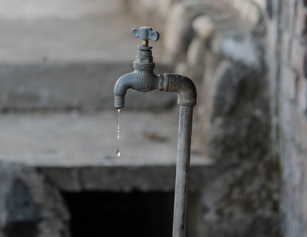 Grifo de agua en desuso con una gota que cae, simbolizando la crisis de suministro en CDMX durante cortes programados.