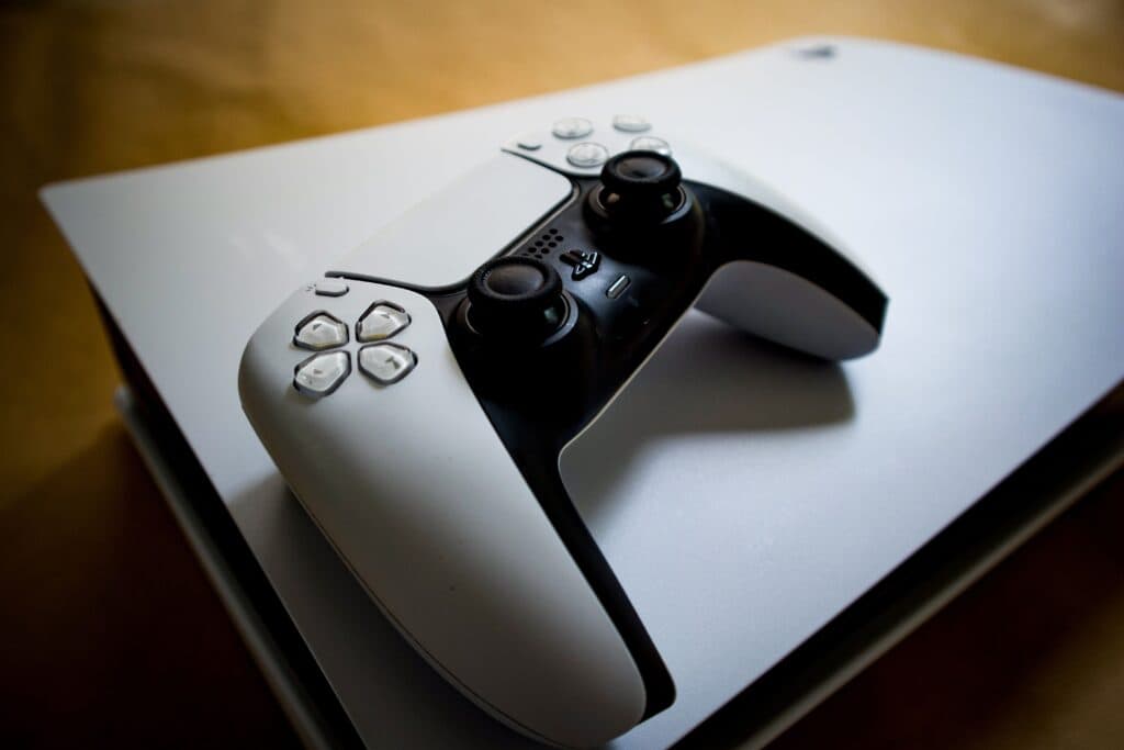 Controlador de PlayStation sobre una consola, simbolizando el cambio hacia el formato digital en los videojuegos.
