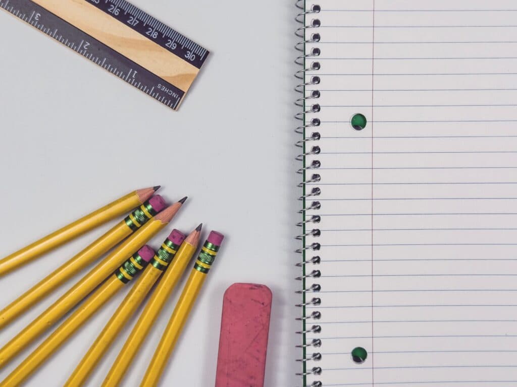 Lápices amarillos, una regla y un cuaderno en blanco sobre una mesa, simbolizando las compras de regreso a clases en México.
