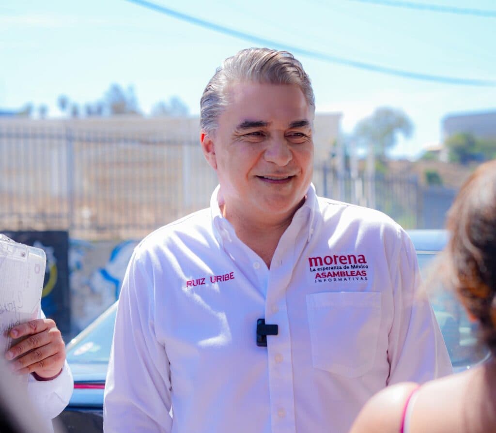 Ruiz Uribe sonríe mientras comparte el mensaje de resultados de Claudia Sheinbaum con vecinos en Lomas Taurinas, Tijuana.