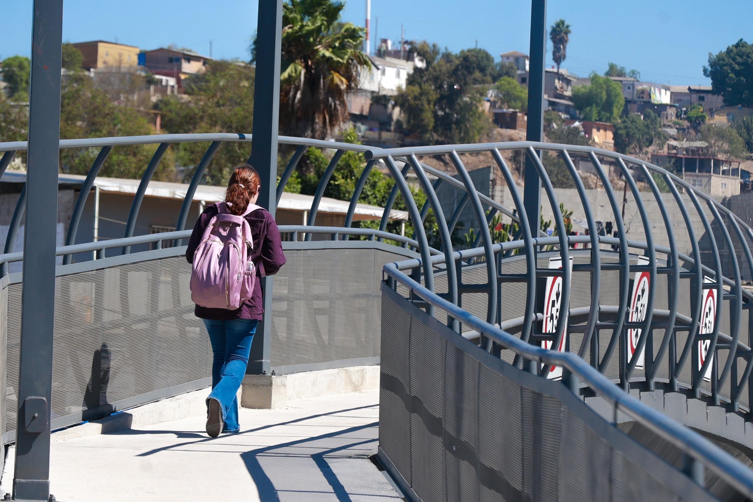 Peatón cruzando el puente peatonal 'Margarito Saldaña' en Tijuana, mejorando la movilidad y seguridad en la zona de Camino Verde.