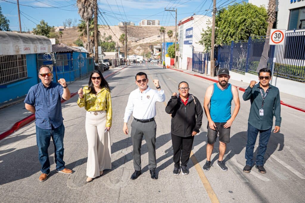 El presidente municipal Abdiel Gutiérrez y funcionarios levantan el puño en señal de triunfo en la calle Miguel Hidalgo, Tijuana.
