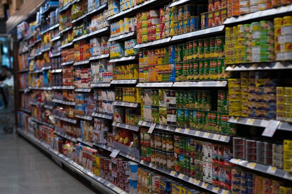 Estantes de supermercado repletos de productos enlatados y envasados, reflejando el debate sobre impuestos en alimentos y bebidas.